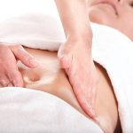 Beautiful girl having stomach massage. Body care.